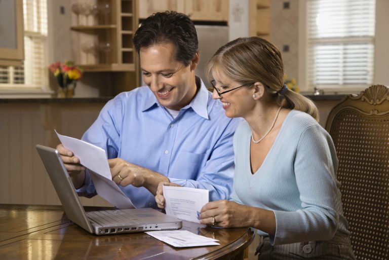 An aging couple checking their bills