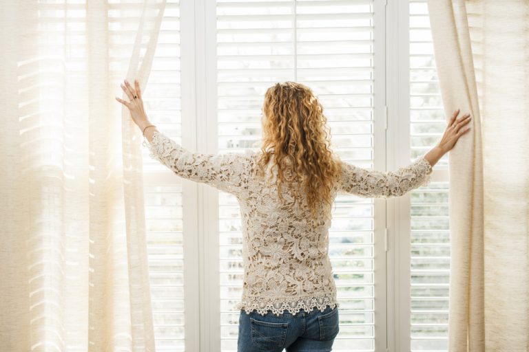woman opening windows in home